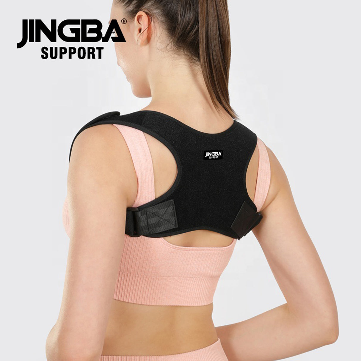 Person wearing a black posture corrector with 'JINGBA SUPPORT' branding on a light gray background. Adjustable Posture Corrector for Back & Shoulder Support (JB-2005) - saska - saska.ae 