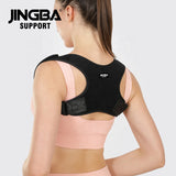 Person wearing a black posture corrector with 'JINGBA SUPPORT' branding on a light gray background. Adjustable Posture Corrector for Back & Shoulder Support (JB-2005) - saska - saska.ae 